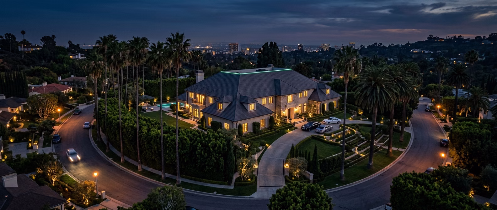 Sweeping hip roof on a Beverly Hills estate home at twilight