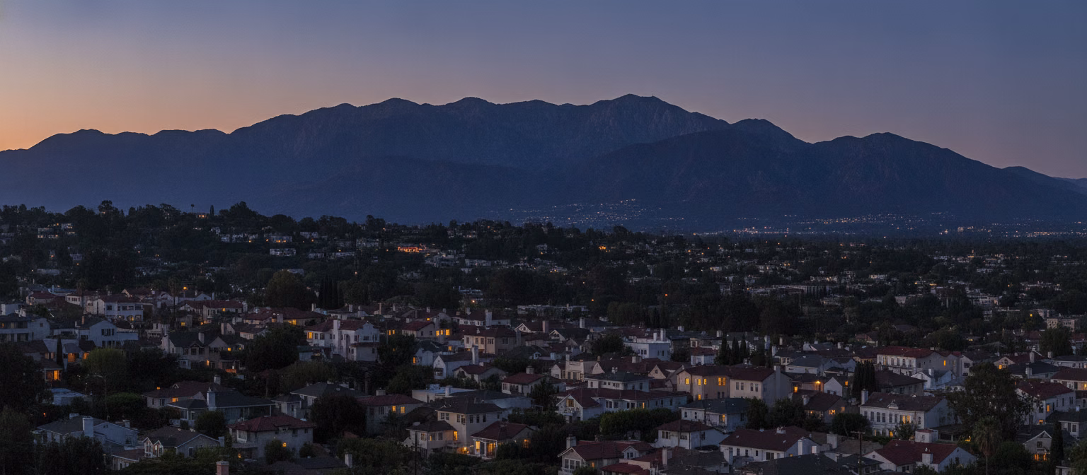 Pasadena rooflines rising toward the foothills at dusk